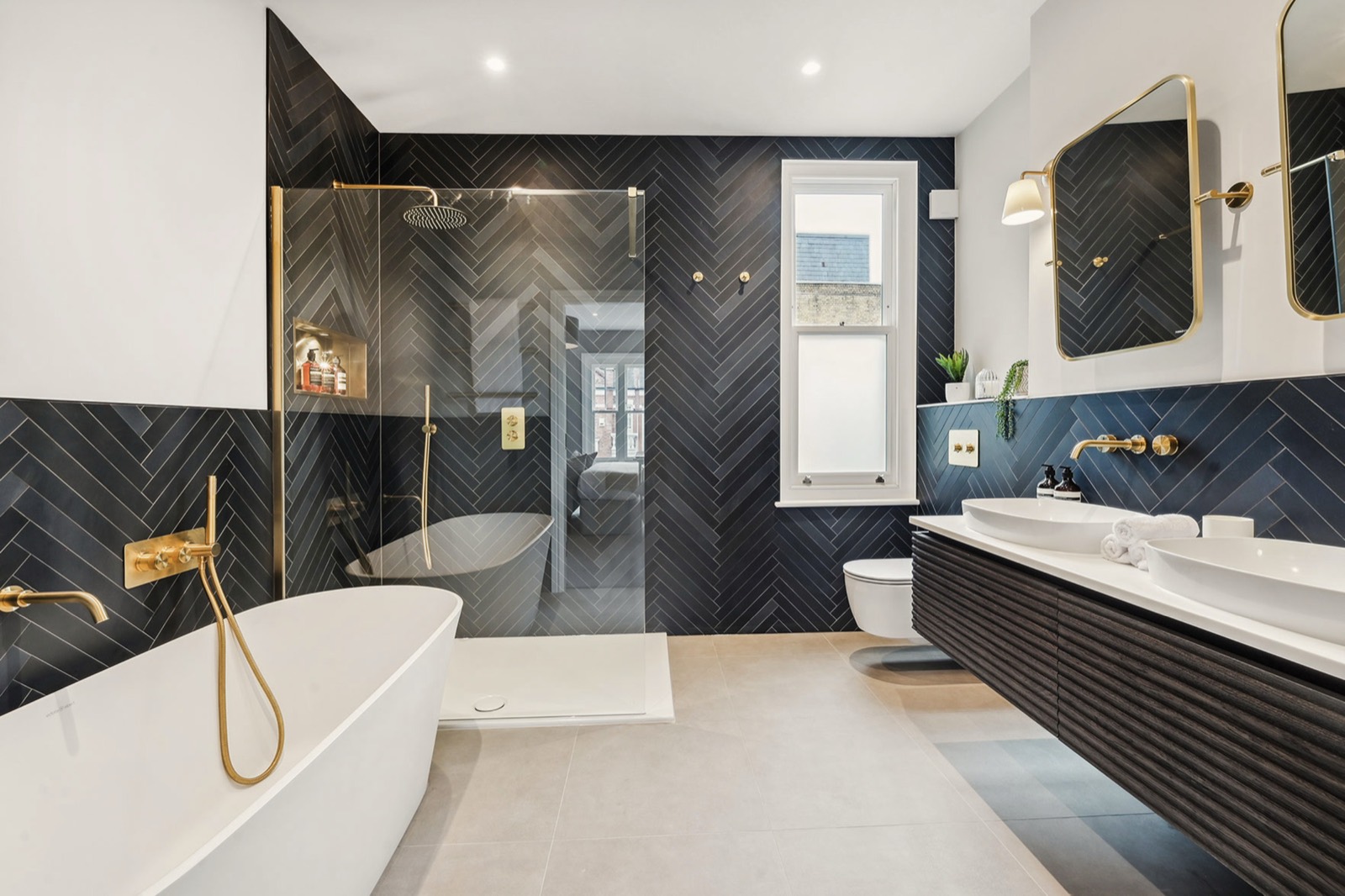 The bathroom, with a freestanding bath and herringbone tiling